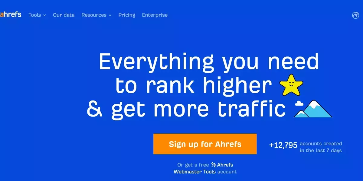 Ahrefs promotional image with a blue background. The headline reads 'Everything you need to rank higher & get more traffic' with a star and mountain emoji. Below, there is an orange button labeled 'Sign up for Ahrefs.' Under the button, the text reads 'Or get a free Ahrefs Webmaster Tools account.' In the top right corner, there is a statistic showing '+12,795 accounts created in the last 7 days.' The top navigation menu includes links to Tools, Our data, Resources, Pricing, and Enterprise.
